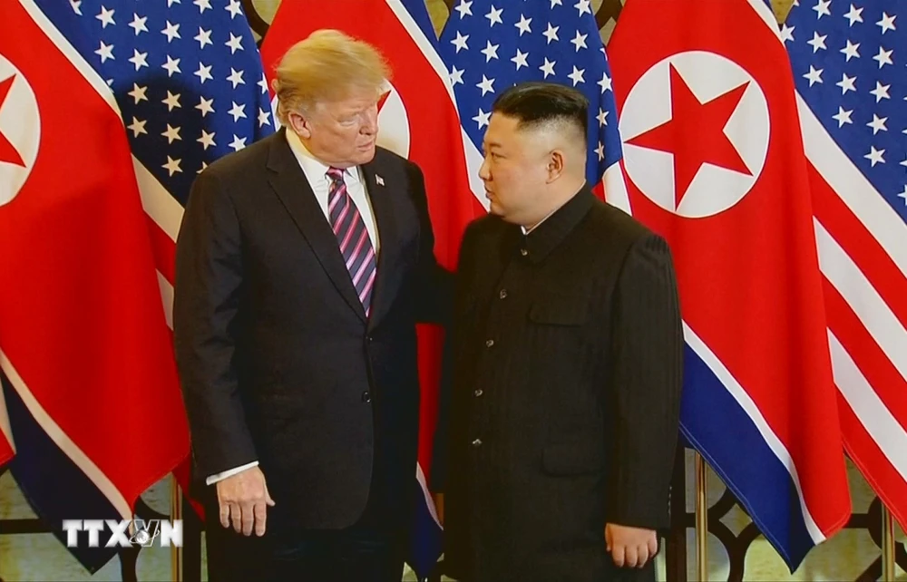 Tổng thống Mỹ Donald Trump và Chủ tịch Triều Tiên Kim Jong-un trao đổi ngắn sau khi bắt tay nhau với biểu cảm khá thân thiện ngày 27/2. (Ảnh: TTXVN)