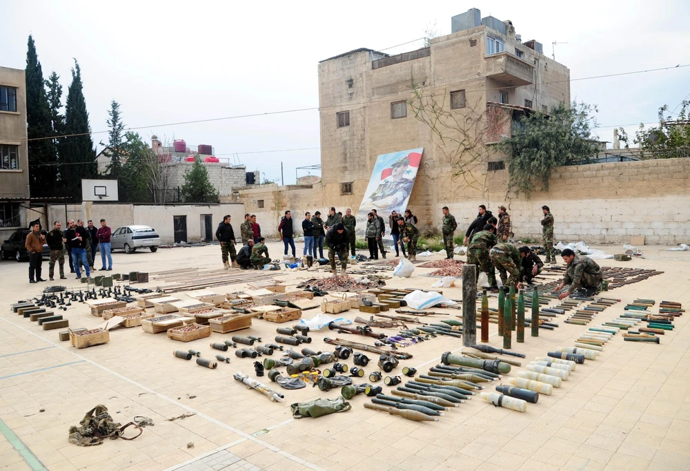 Binh sỹ Syria trưng bày số vũ khí thu giữ của phiến quân tại căn cứ quân sự ở phía bắc Damascus ngày 22/11/2018. (Ảnh: THX/TTXVN)