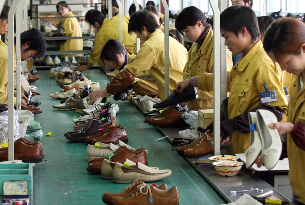 Công nhân sản xuất giầy tại nhà máy của Hãng Kangnai, thành phố Ôn Châu, tỉnh Chiết Giang, Trung Quốc. (Ảnh: AFP/TTXVN)