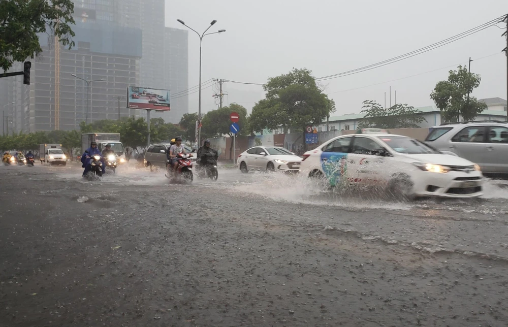 Các phương tiện lưu thông trong nước ngập trên đường Nguyễn Hữu Cảnh, quận Bình Thạnh. (Ảnh: Xuân Dự/TTXVN)