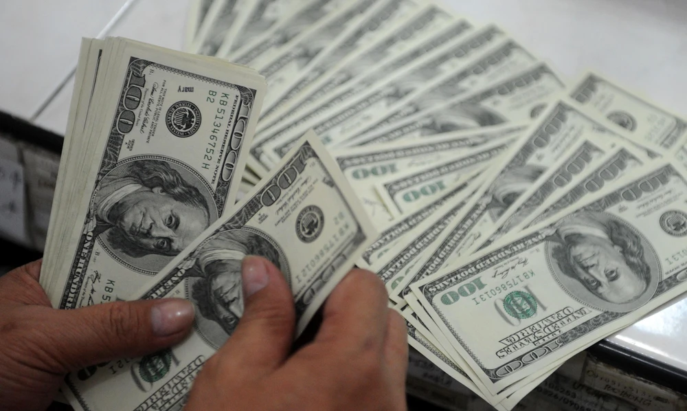 Kiểm tiền USD tại quầy ngoại hối ở Manila, Philippines. (Ảnh: AFP/TTXVN)