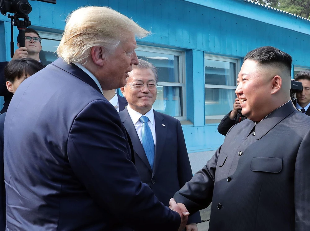 Tổng thống Mỹ Donald Trump (trái), nhà lãnh đạo Triều Tiên Kim Jong-un (phải) và Tổng thống Hàn Quốc Moon Jae-in (giữa) trong cuộc gặp tại Khu phi quân sự (DMZ) ngày 30/6. (Ảnh: AFP/TTXVN)