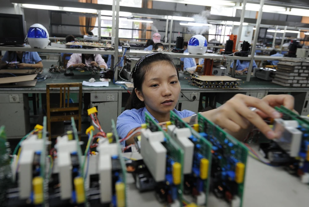 Công nhân làm việc tại một nhà máy sản xuất thiết bị điện tử ở tỉnh An Huy, Trung Quốc. (Ảnh: AFP/TTXVN)