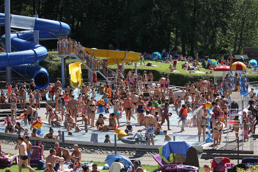 Người dân tránh nắng nóng tại bể bơi ở Huizingen, Bỉ. (Ảnh: AFP/TTXVN)