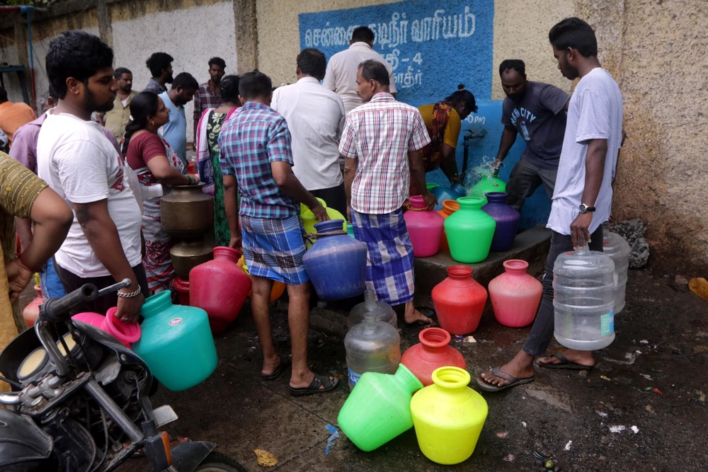 Người dân xếp hàng chờ lấy nước sinh hoạt tại Chennai, Ấn Độ ngày 25/6. (Ảnh: THX/TTXVN)