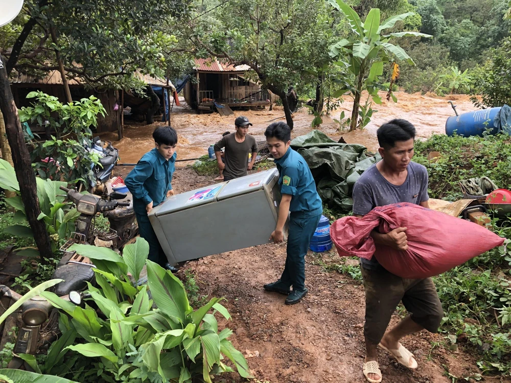 Lực lượng dân quân hỗ trợ người dân di dời tài sản ra khỏi vùng lũ. (Ảnh: Đậu Tất Thành/TTXVN)