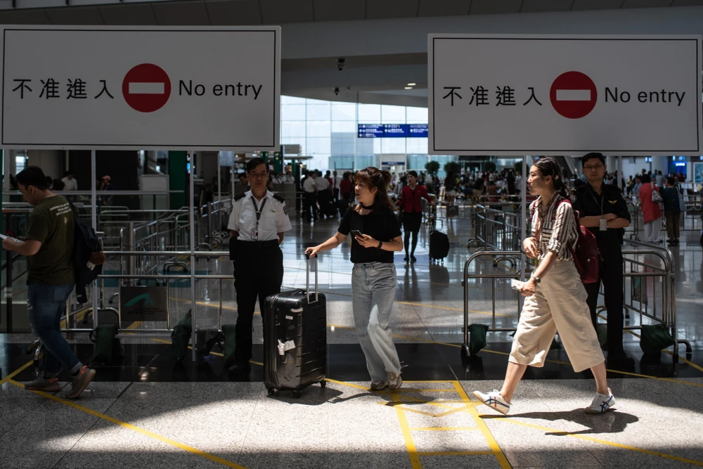 Hành khách làm thủ tục tại sân bay quốc tế Hong Kong ngày 14/8. (Ảnh: AFP/TTXVN)