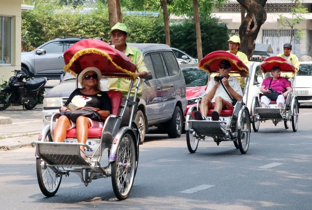 Du khách quốc tế tham quan thành phố Đà Nẵng bằng xíchlô. (Ảnh: Trần Lê Lâm/TTXVN)