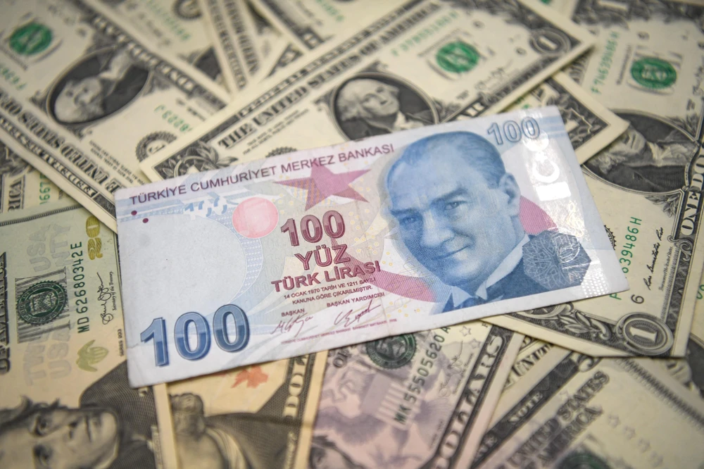 Đồng lira (giữa) của Thổ Nhĩ Kỳ và đồng đô la Mỹ. (Ảnh: AFP/ TTXVN)