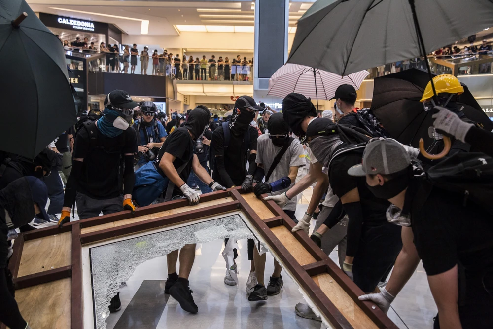 Người biểu tình quá khích che mặt phá hoại tại một trung tâm thương mại ở Sha Tin, Hong Kong ngày 22/9/2019. (Ảnh: AFP/TTXVN)