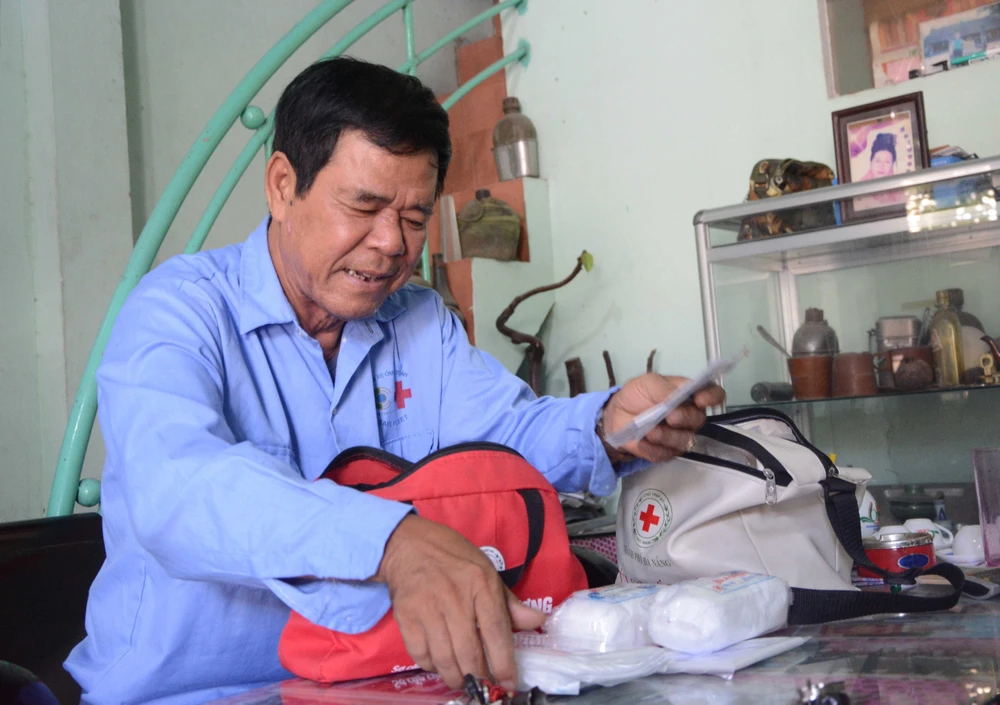 Ông Đặng Thanh Kinh, thành viên của đội "Xe ôm an toàn" thường xuyên kiểm tra túi sơ cứu. (Ảnh: Văn Dũng/TTXVN)