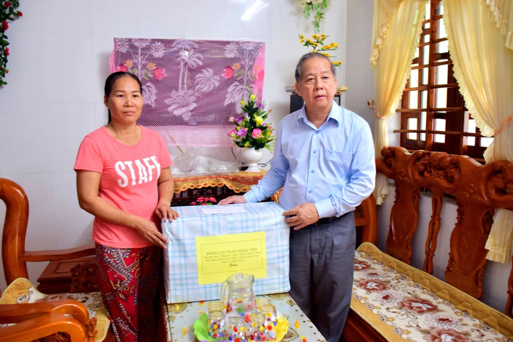 Chủ tịch UBND tỉnh Phan Ngọc Thọ tặng quà cho gia đình có người thân bị mất tại Làng Rồng, thị Trấn Thuận An, huyện Phú Vang. (Ảnh: Tường Vi/TTXVN)