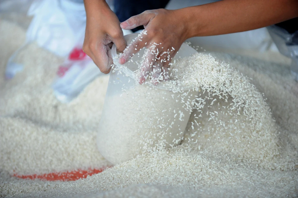 Người dân đong gạo tại Manila, Philippines. (Ảnh: AFP/TTXVN)