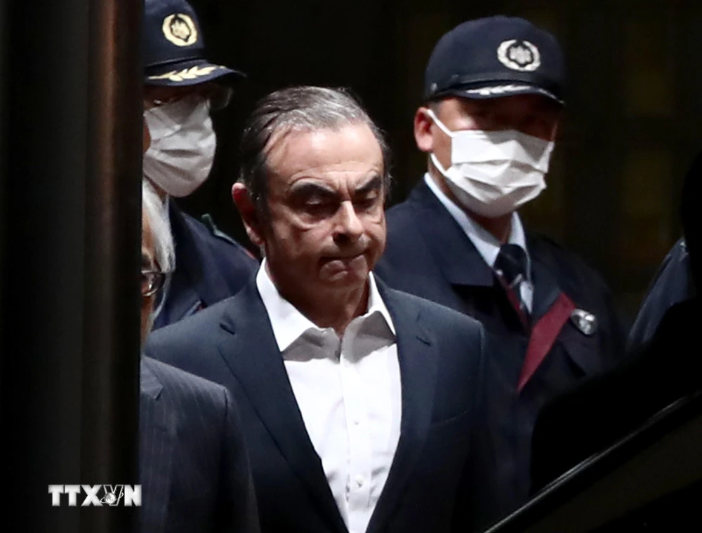 Cảnh sát áp giải cựu Chủ tịch Nissan Carlos Ghosn (giữa) rời khỏi khu giam giữ ở Tokyo, sau khi ông được trả tự do có bảo lãnh, ngày 25/4/2019. (Ảnh: AFP/TTXVN)