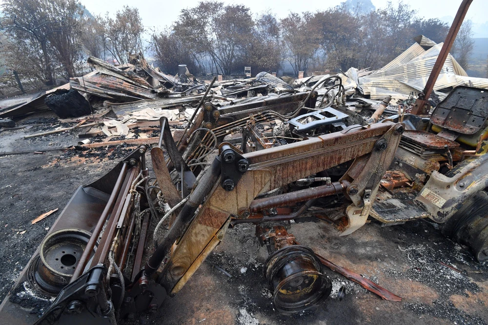 Nhà cửa và phương tiện bị tàn phá sau cháy rừng tại bang New South Wales, Australia ngày 6/1/2020. (Ảnh: AFP/TTXVN)