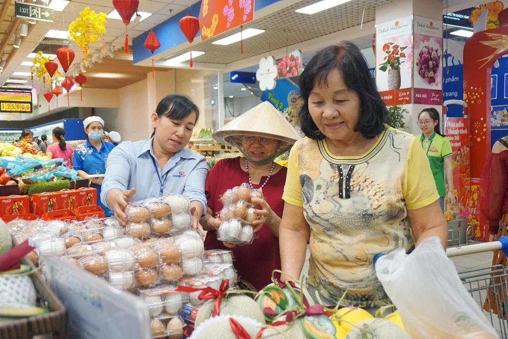 Nhân viên siêu thị liên tục bổ sung hàng hóa phục vụ nhu cầu mua sắm của người dân. (Ảnh: TTXVN phát)