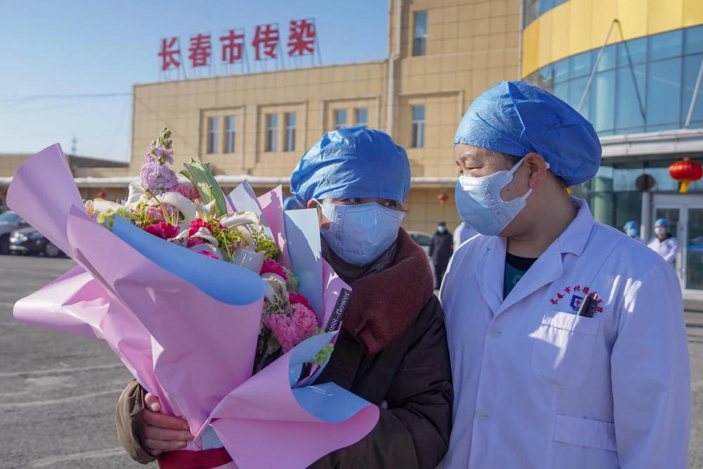 Bệnh nhân nhiễm virus corona (trái) được xuất viện sau khi điều trị tại bệnh viện ở Trường Xuân, tỉnh Cát Lâm, Trung Quốc, ngày 30/1/2020. (Ảnh: THX/TTXVN)