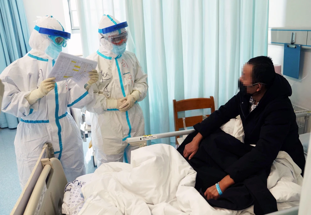 Nhân viên y tế kiểm tra tình trạng bệnh nhân nhiễm COVID-19 đang được điều trị tại một bệnh viện ở Vũ Hán, Trung Quốc ngày 18/2/2020. (Ảnh: THX/TTXVN)