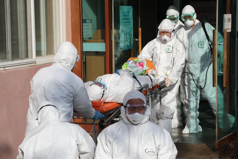 Nhân viên y tế Hàn Quốc chuyển bệnh nhân nhiễm COVID-19 từ một bệnh viện ở Cheongdo đến một bệnh viện khác để điều trị ngày 21/2/2020. (Ảnh: Yonhap/TTXVN)