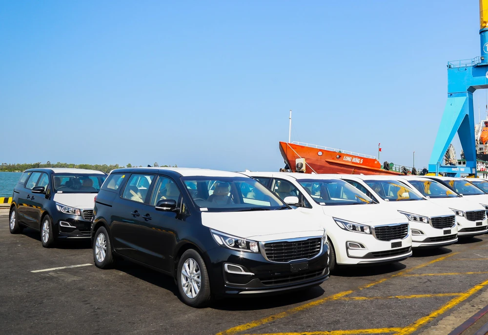 Lô xe Kia Grand Carnival được đưa vào container tại Khu công nghiệp THACO Chu Lai (Quảng Nam) để xuất khẩu sang Thái Lan. (Nguồn: PV/Vietnam+)