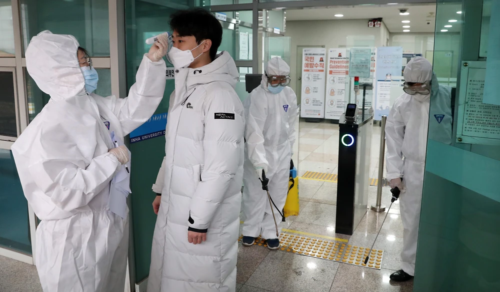 Nhân viên y tế kiểm tra thân nhiệt của sinh viên tại trường đại học Inha ở Incheon, Hàn Quốc, ngày 25/2/2020. (Ảnh: THX/TTXVN)