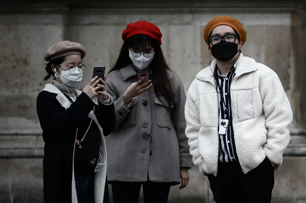 Du khách đeo khẩu trang đề phòng lây nhiễm COVID-19 tại Paris, Pháp ngày 31/1/2020. (Ảnh: AFP/TTXVN)