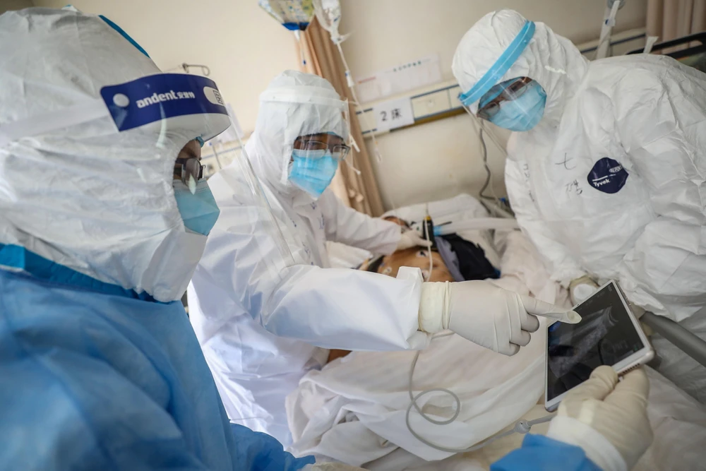 Nhân viên y tế điều trị cho bệnh nhân nhiễm COVID-19 tại bệnh viện ở Vũ Hán, Trung Quốc, ngày 16/2. (Ảnh: AFP/TTXVN)