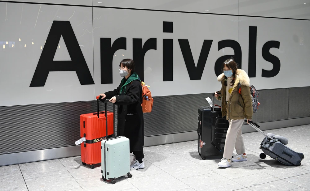 Hành khách đeo khẩu trang để phòng tránh lây nhiễm virus corona chủng mới gây dịch viêm phổi tại sân bay Heathrow, London, Anh, ngày 28/1/2020. (Ảnh: AFP/TTXVN)