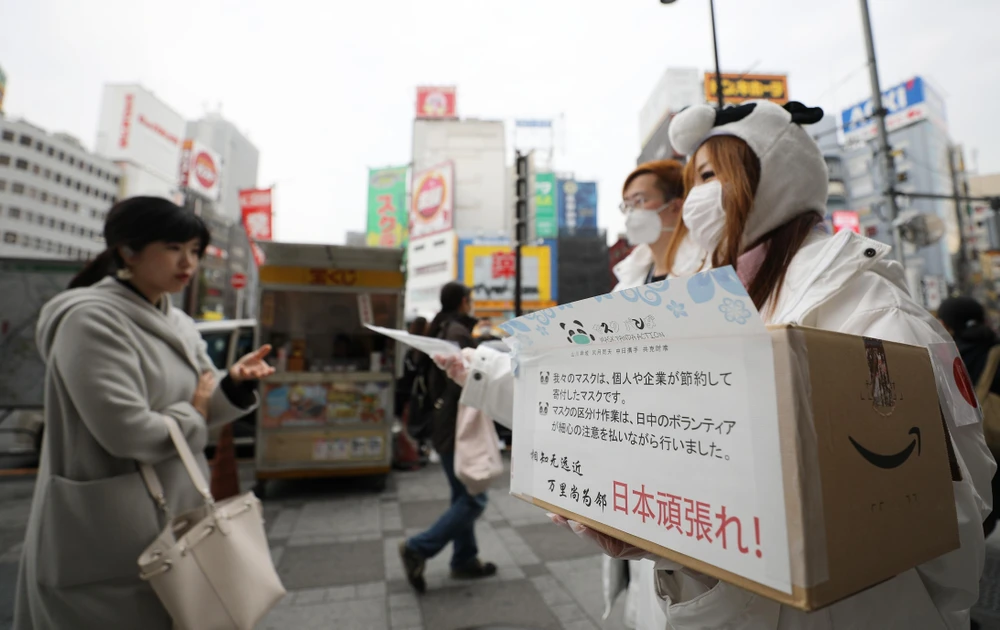 Phát khẩu trang miễn phí để phòng tránh lây nhiễm COVID-19 tại Tokyo, Nhật Bản, ngày 7/3. (Ảnh: THX/TTXVN)