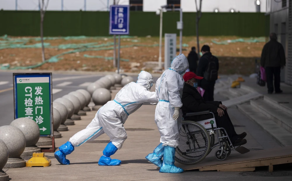 Nhân viên y tế chuyển bệnh nhân nhiễm COVID-19 tại một bệnh viện ở Vũ Hán, Trung Quốc ngày 14/3/2020. (Ảnh: THX/TTXVN)