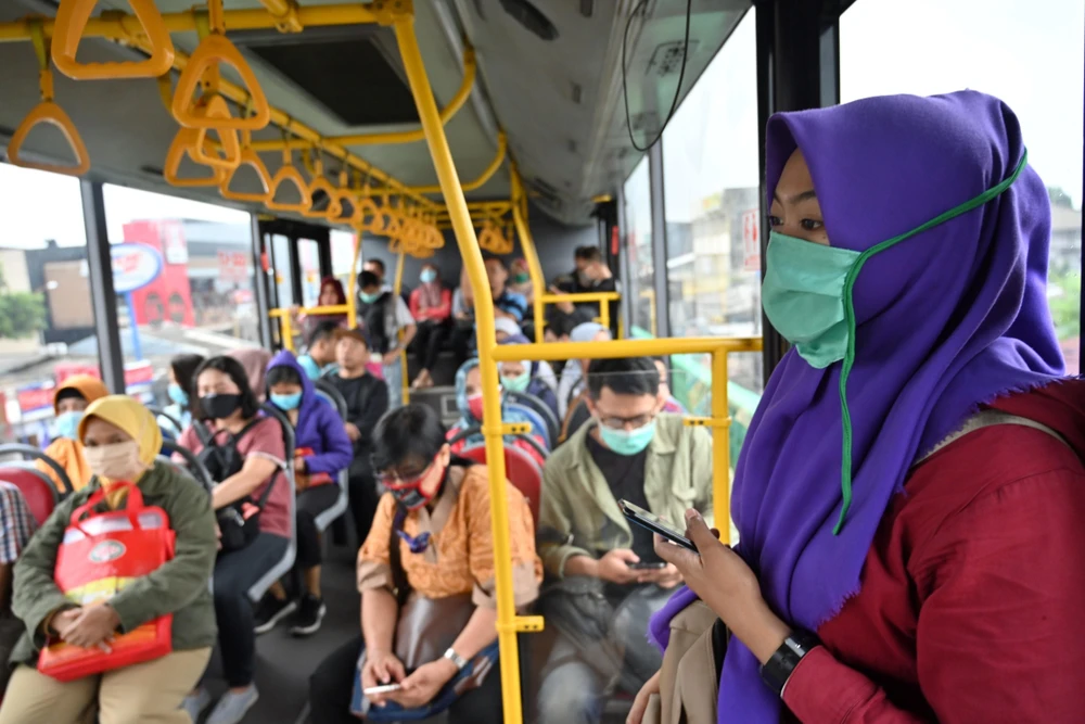 Hành khách đeo khẩu trang phòng lây nhiễm COVID-19 tại Jakarta, Indonesia, ngày 18/3/2020. (Ảnh: AFP/TTXVN)