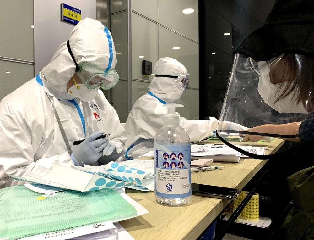 Nhân viên y tế cung cấp thông tin về dịch COVID-19 tại sân bay quốc tế ở Thượng Hải, Trung Quốc, ngày 15/3/2020. (Ảnh: THX/TTXVN)