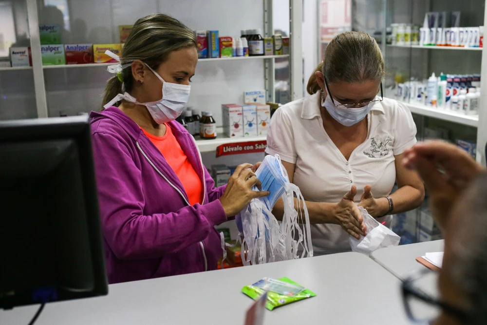 Người dân mua khẩu trang và dung dịch sát khuẩn tại một cửa hàng ở Caracas, Venezuela, ngày 13/3. (Ảnh: AFP/TTXVN)