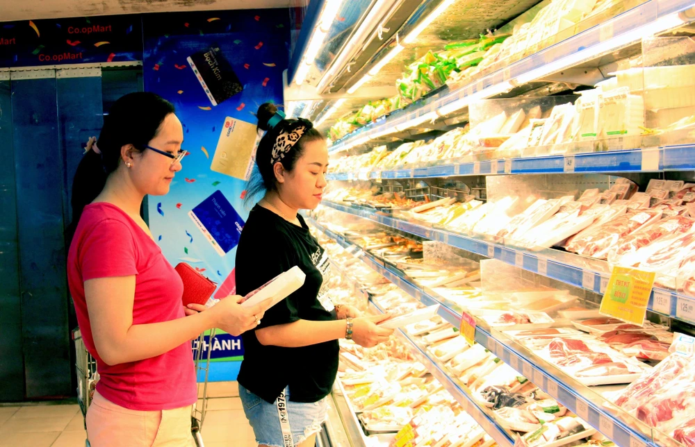 Khách hàng chọn mua thịt lợn tại siêu thị Co.opmart Hà Đông (Hà Nội). (Ảnh: Quang Quyết/TTXVN)