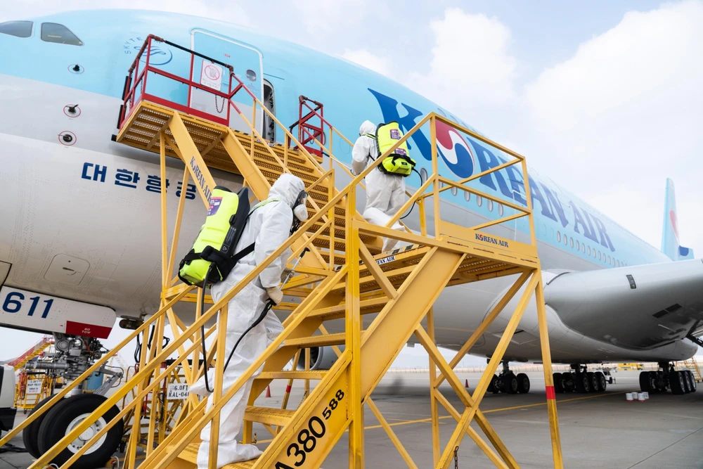 Nhân viên chuẩn bị phun thuốc khử trùng trên máy bay của Korean Air nhằm ngăn chặn sự lây lan của dịch COVID-19 tại sân bay quốc tế Incheon, Hàn Quốc, ngày 4/3. (Ảnh: AFP/TTXVN)