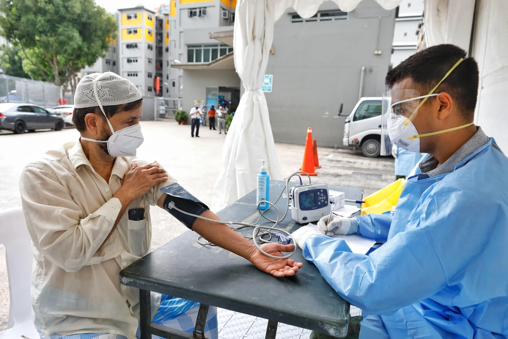 Nhân viên y tế kiểm tra sức khỏe cho người lao động nhập cư tại khu ký túc xá Toh Guan, Singapore ngày 8/4/2020. (Ảnh: THX/TTXVN)