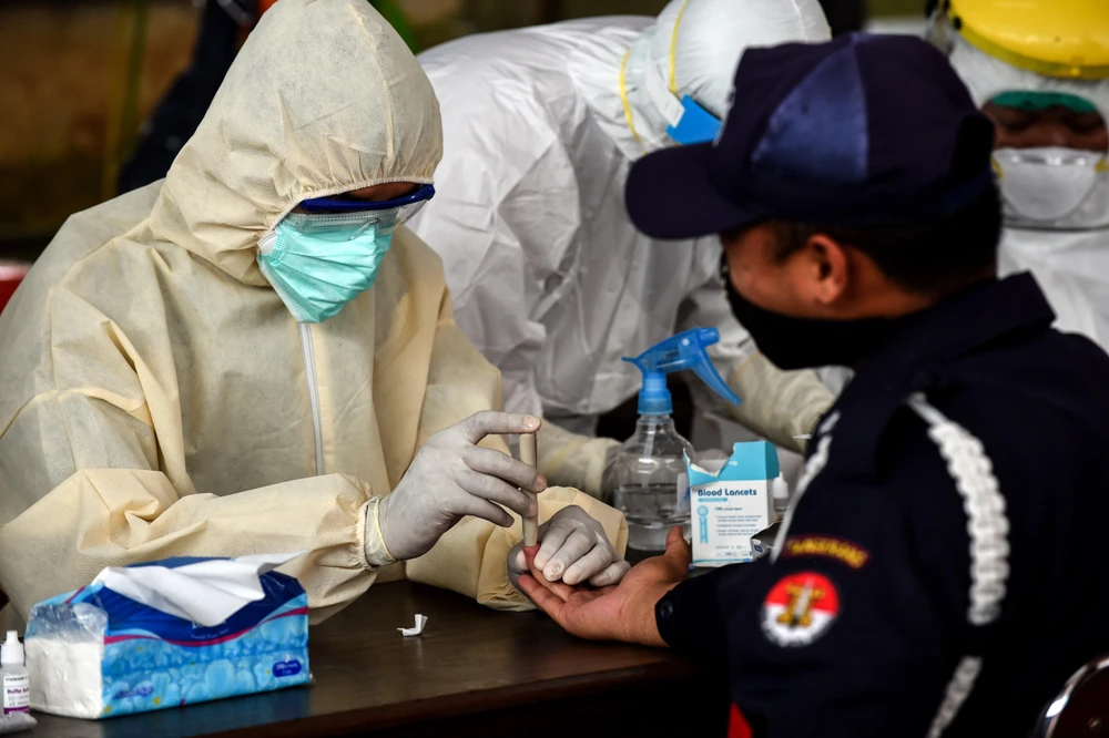 Nhân viên y tế lấy mẫu xét nghiệm nhanh COVID-19 tại một chợ ở Banten, Indonesia, ngày 21/4/2020. (Ảnh: THX/TTXVN)