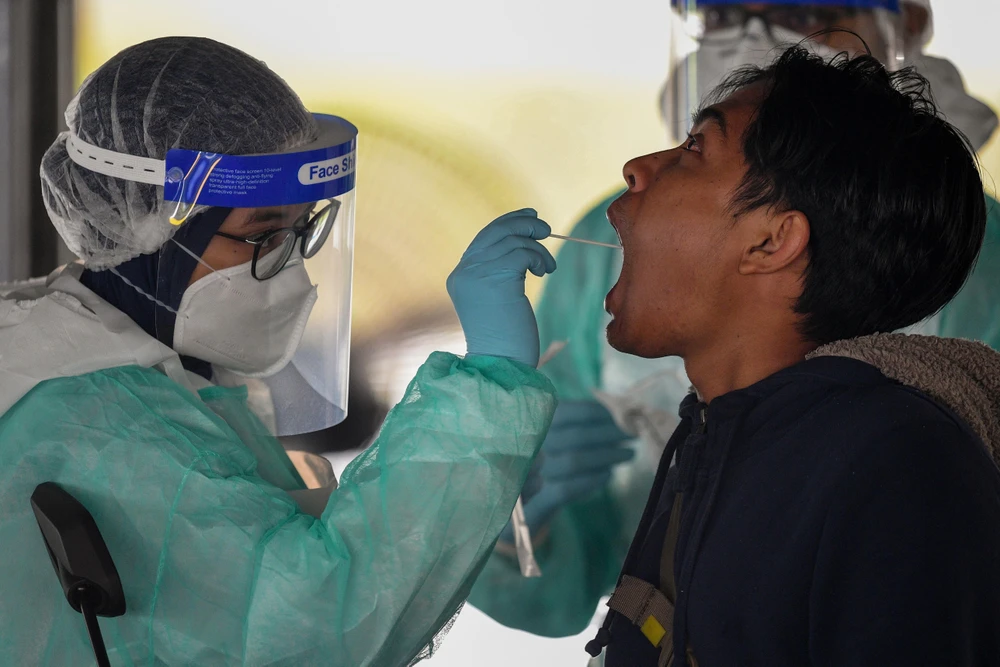 Nhân viên y tế kiểm tra thân nhiệt người dân nhằm ngăn ngừa dịch COVID-19 ở Gombak, ngoại ô Kuala Lumpur, Malaysia. (Ảnh: AFP/TTXVN)