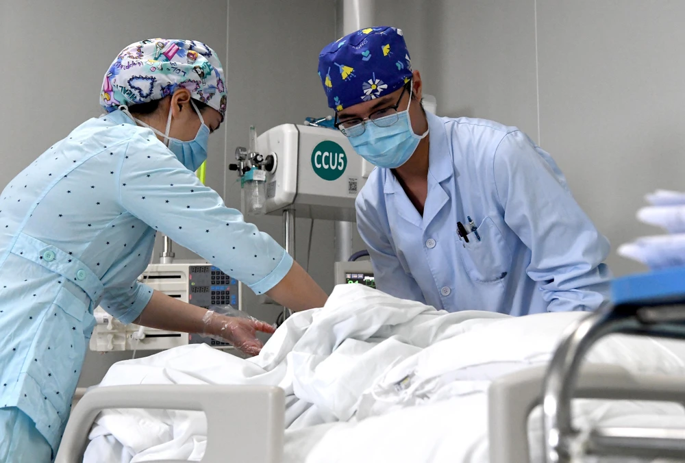 Nhân viên y tế chăm sóc bệnh nhân mắc COVID-19 tại một bệnh viện ở Hà Nam, Trung Quốc ngày 26/4/2020. (Ảnh: THX/TTXVN)