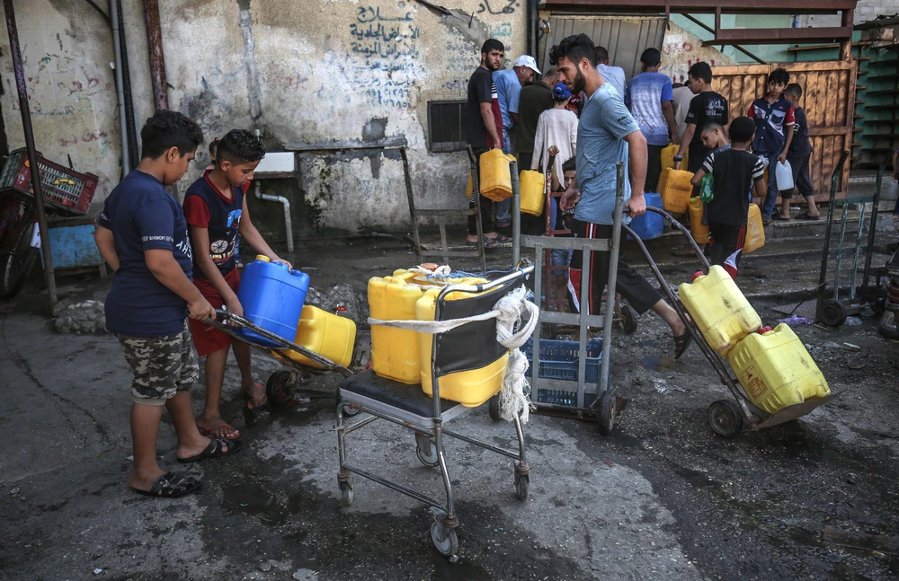 Trẻ em Palestine xếp hàng lấy nước uống tại một trại tị nạn ở Rafah, Dải Gaza ngày 30/7/2019. (Ảnh: AFP/TTXVN)