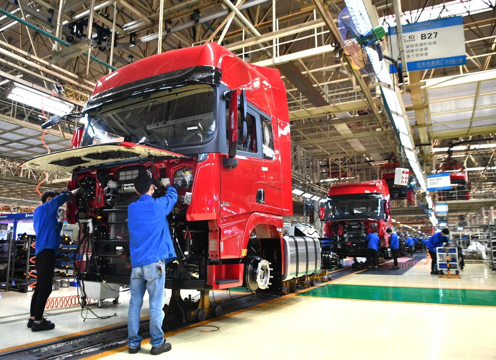 Công nhân làm việc tại dây chuyền sản xuất xe tải hạng nặng của Tập đoàn sản xuất ôtô Thiểm Tây, Trung Quốc ngày 23/4/2020. (Ảnh: THX/TTXVN)