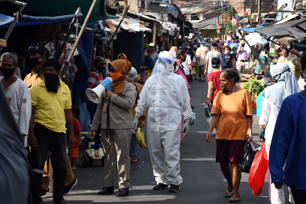 Nhân viên y tế kêu gọi người dân xét nghiệm COVID-19 tại một khu chợ ở Jakarta, Indonesia ngày 2/6/2020. (Ảnh: THX/TTXVN)