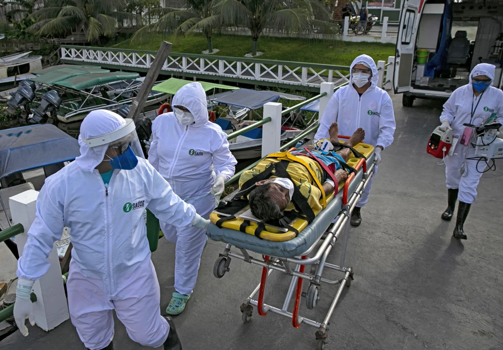 Nhân viên y tế chuyển bệnh nhân mắc COVID-19 tới bệnh viện ở Breves, Brazil. (Ảnh: AFP/TTXVN)