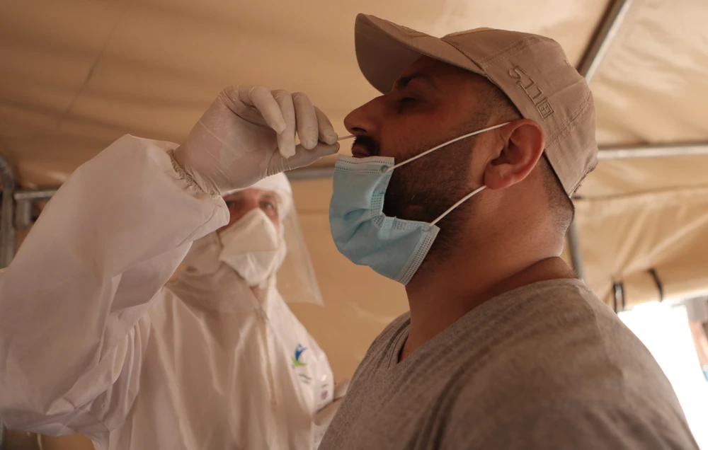 Nhân viên y tế lấy mẫu xét nghiệm COVID-19 tại Hebron, Khu Bờ Tây, Mỹ. (Ảnh: THX/TTXVN)