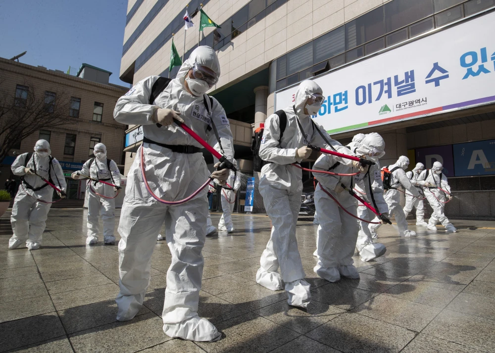 Phun thuốc khử trùng nhằm ngăn chặn sự lây lan của dịch COVID-19 tại thành phố Daegu, Hàn Quốc. (Ảnh: THX/TTXVN)
