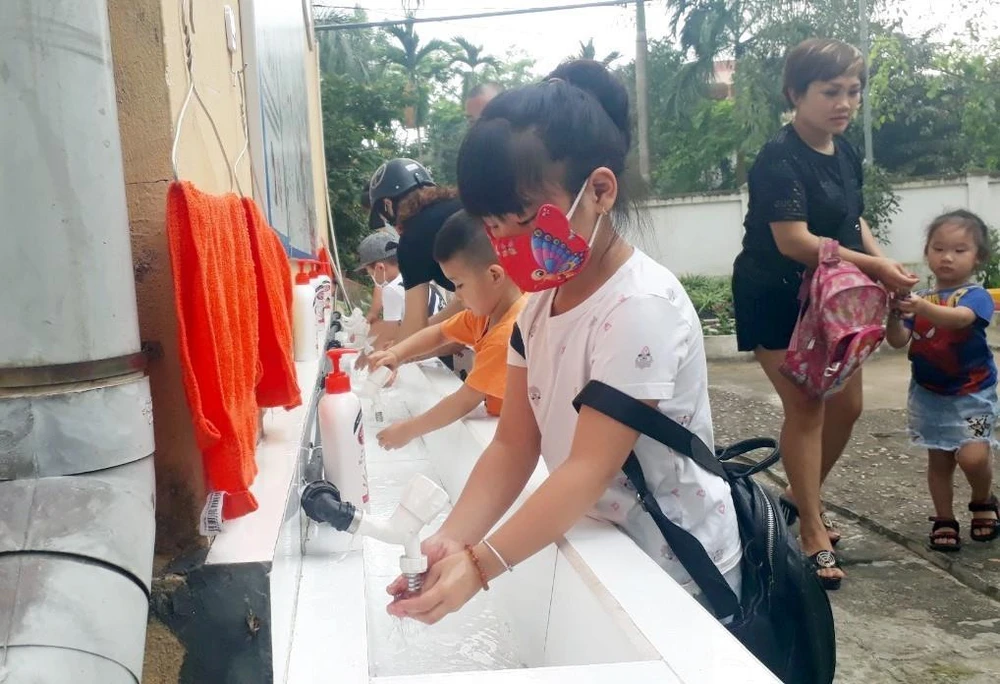 Học sinh Trường mầm non Ỷ La, thành phố Tuyên Quang rửa tay bằng xà phòng trước khi vào lớp. (Ảnh: Quang Cường/TTXVN)