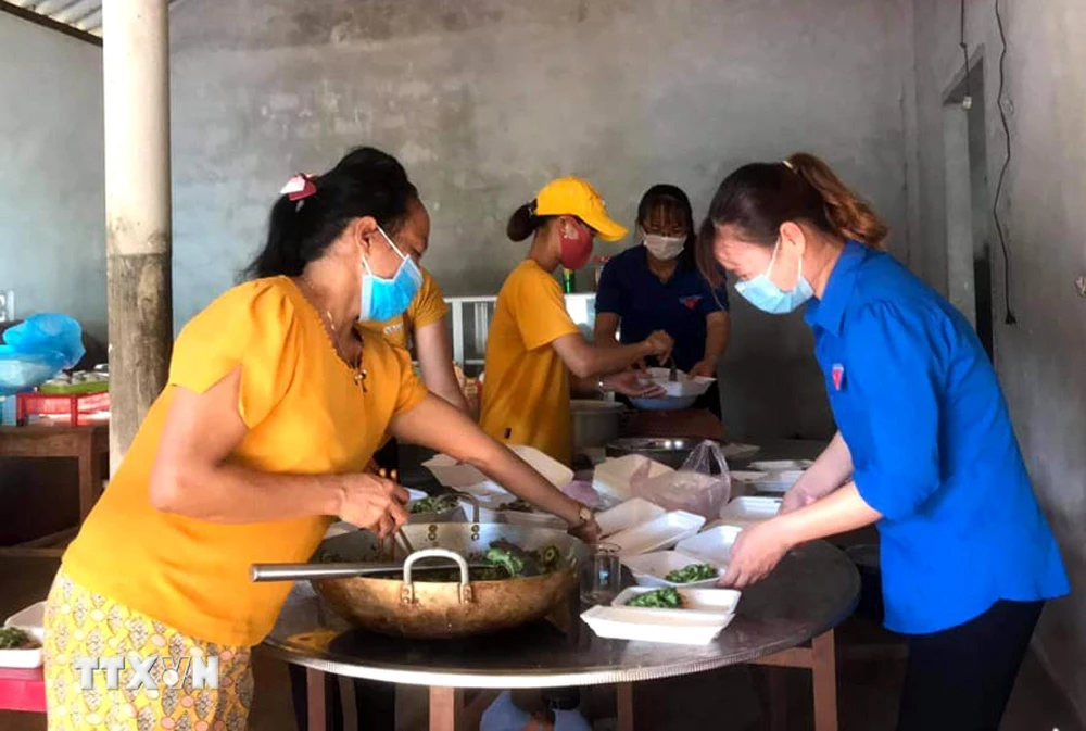 Đoàn Thanh niên và Hội Phụ nữ xã Vĩnh Hòa chuẩn bị những suất ăn, hỗ trợ lực lượng làm nhiệm vụ phong tỏa thôn Đơn Duệ. (Ảnh: TTXVN)
