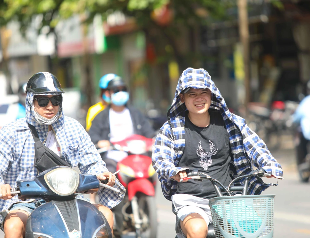 Thời tiết nắng nóng, tia UV ở mức cao, người dân cần trang bị tốt đồ bảo hộ khi ra đường để bảo vệ sức khỏe. (Ảnh: Thanh Tùng/TTXVN)