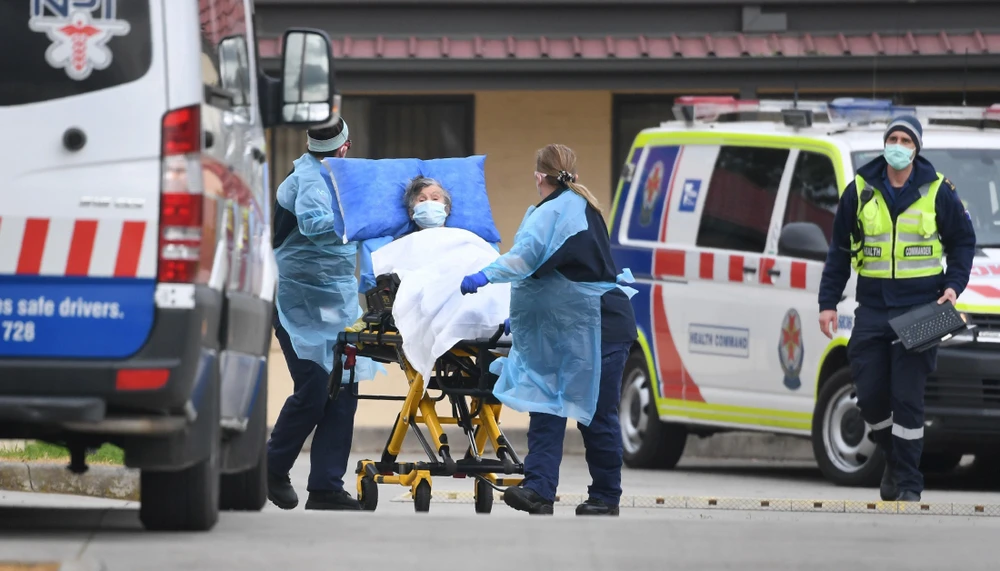 Nhân viên y tế chuyển bệnh nhân mắc COVID-19 lên xe cứu thương tại ngoại ô thành phố Melbourne, bang Victoria, Australia ngày 27/7/2020. (Ảnh: AFP/TTXVN)