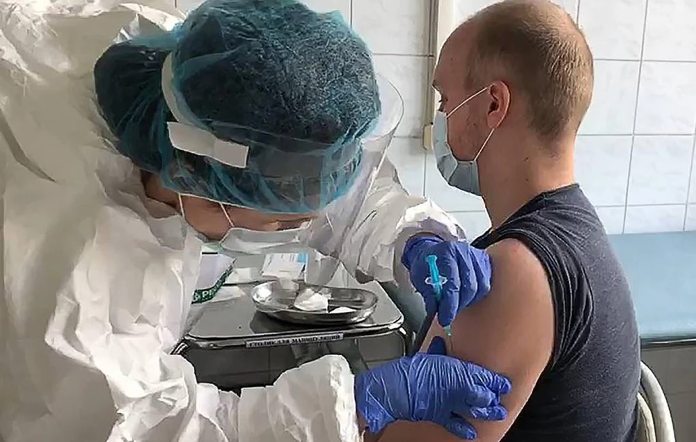 Nhân viên y tế tiêm vaccine ngừa COVID-19 cho tình nguyện viên tại Nga. (Ảnh: TASS/TTXVN)